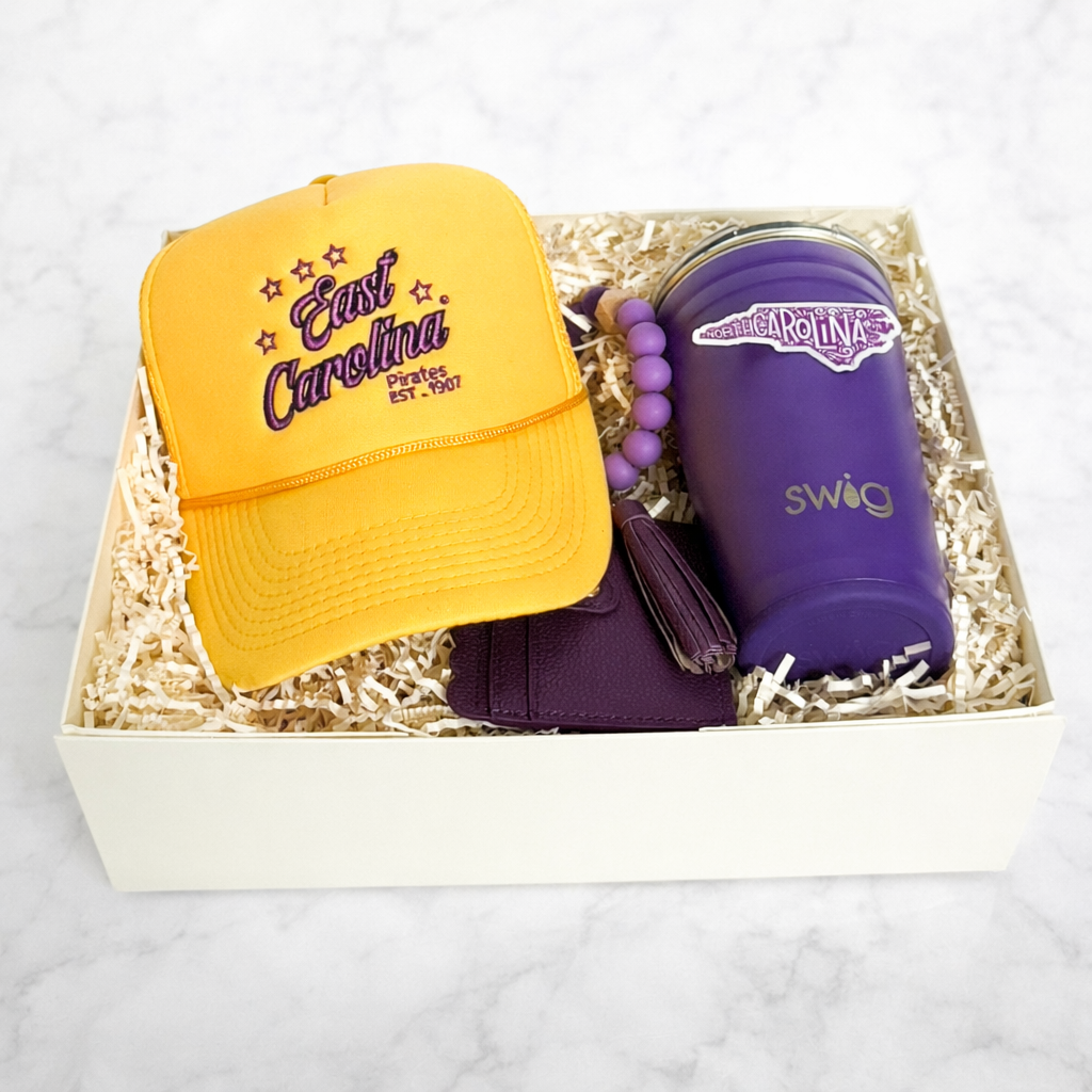 ECU graduation gift box with Swig tumbler, trucker hat, card holder wristlet and purple North Carolina sticker